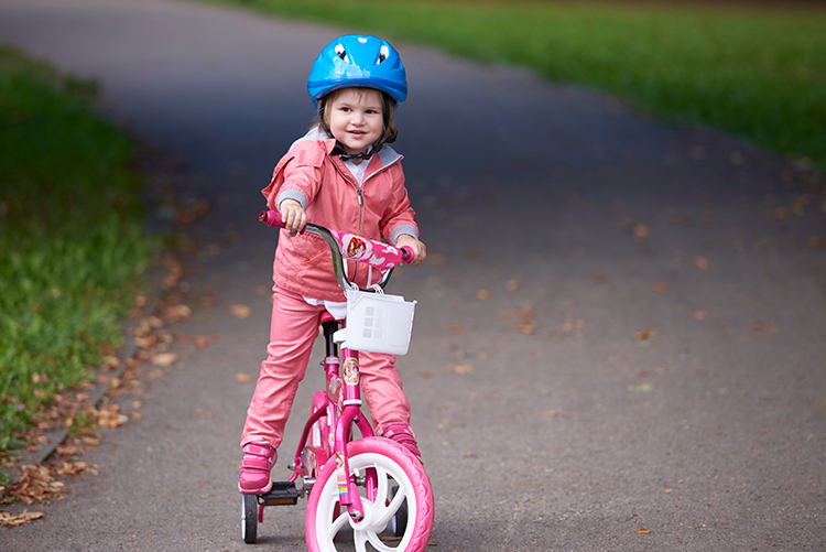 Niña aprendiendo a subirse en una bicicleta